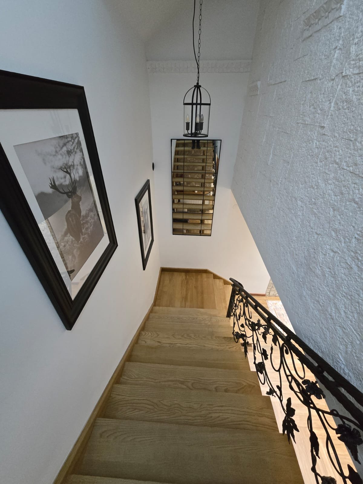 Klatka schodowa z kutą balustradą i żyrandolem-latarnią